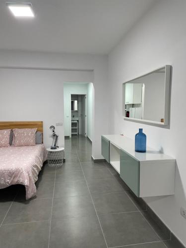 ein Schlafzimmer mit einem Bett und einem großen Spiegel in der Unterkunft Enjoy Las Canteras in Las Palmas de Gran Canaria