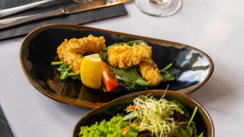 a plate of food on a table with a salad at Centennial Court Hotel in Alexandra