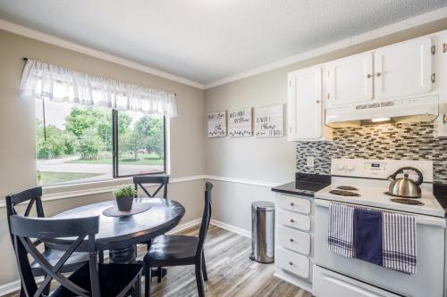 a kitchen with a table and a kitchen with white cabinets at Cute Condo in Rock Hill-53 in Rock Hill