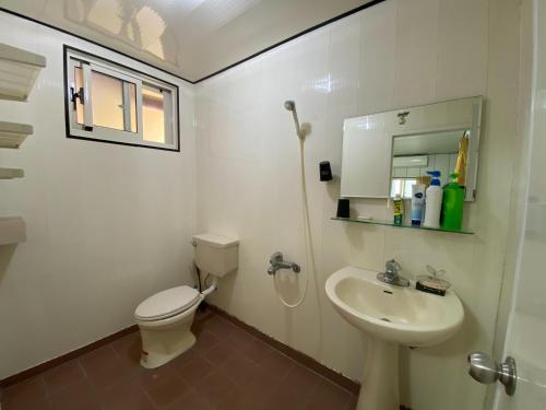 a white bathroom with a toilet and a sink at 好貨舍 in Xiaoliuqiu