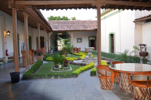 a patio with a table and chairs and a garden at Hotel La Merced in Colima