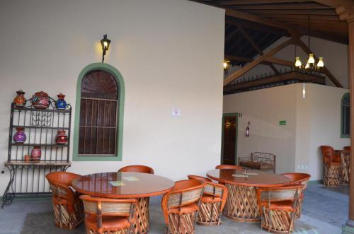 a group of tables and chairs in a room at Hotel La Merced in Colima