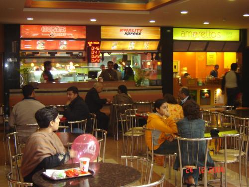 un grupo de personas sentadas en mesas en un restaurante en Savoy Greens Karnal en Karnal