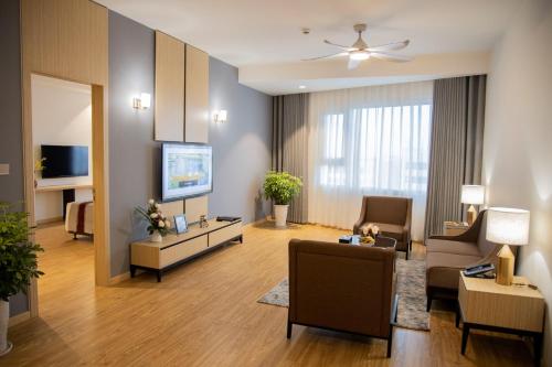 a living room with a couch and a tv at Pearl River Hotel in Hai Phong