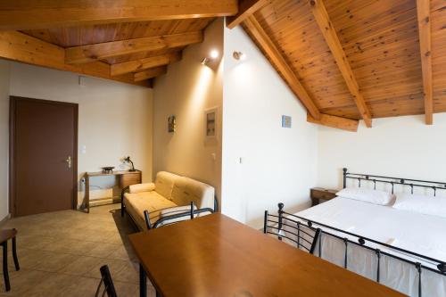 a room with a bed and a table and chairs at The Loft Studio in Lixouri