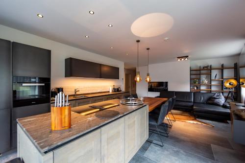 a kitchen and living room with a table and a couch at LUVA Resorts Kappl - Chalet K in Kappl