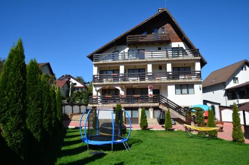 a house with a playground in the yard at Pensiunea Antonia in Bran