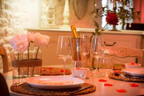 a table with wine glasses and flowers on it at Gîte Love Dream - Le Gîte Romantique in Ger