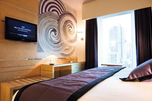 a bedroom with a bed and a tv and a window at Riu Plaza Panamá in Panama City