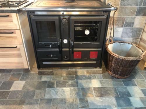 a black oven with a basket in a kitchen at Chalet Schwendli in Schwarzsee