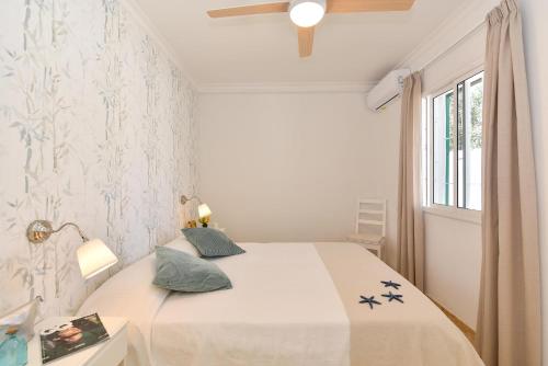 a white bedroom with a bed and a window at Chalet Golden Sahara by VillaGranCanaria in Playa del Ingles