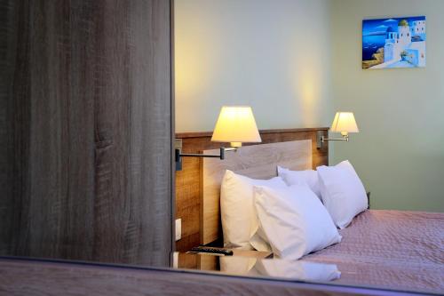a bedroom with a bed with white pillows and a mirror at Stalaktites Studios in Sami
