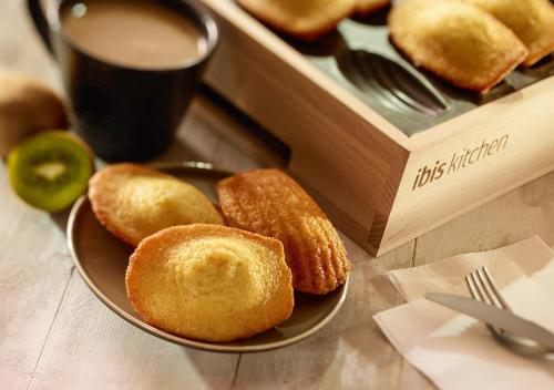a plate of donuts on a table next to a box at ibis Nancy Centre Stanislas in Nancy