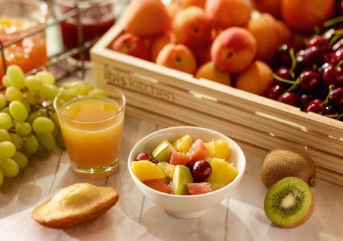 a table with a bowl of fruit and a glass of orange juice at ibis Nancy Centre Stanislas in Nancy