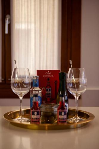 a tray with two glasses and bottles of wine at Ca' della Scimmia - Rialto Bridge, Venice in Venice