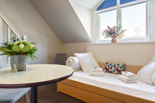 Cette chambre comprend un lit avec une table et une fenêtre. dans l'établissement Appart'City Classic Nantes Viarme, à Nantes