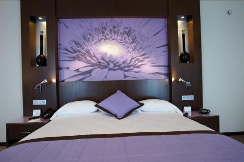a bedroom with a bed with a purple flower on the wall at Riu Plaza Panamá in Panama City