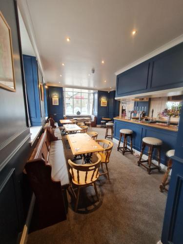 a restaurant with blue walls and tables and chairs at Y Griffin in Penrhyndeudreath