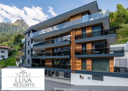 a building with a mountain in the background at LUVA Resorts Kappl - Chalet K in Kappl
