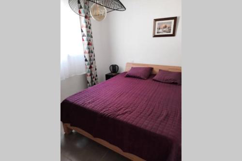 a bedroom with a bed with a purple bedspread at SUPERBE VILLA 85 m2 NIMES CAREMEAU in Nîmes