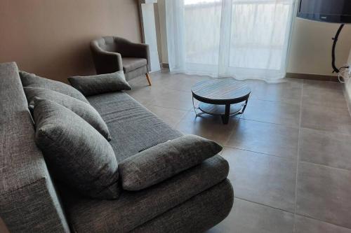 a living room with a couch and a table at SUPERBE VILLA 85 m2 NIMES CAREMEAU in Nîmes