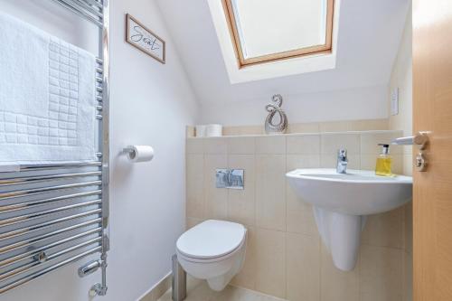 a white bathroom with a toilet and a sink at London Heathrow Living Holywell Serviced Houses - 3 and 4 bedrooms By Ferndale in Stanwell