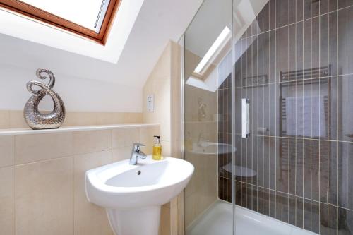a bathroom with a sink and a glass shower at London Heathrow Living Holywell Serviced Houses - 3 and 4 bedrooms By Ferndale in Stanwell