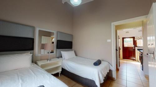 a bedroom with two beds and a door to a kitchen at San Lameer Villa 2910 by Top Destinations Rentals in Southbroom