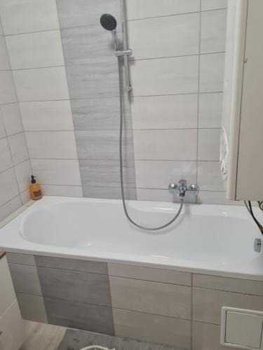 bañera con ducha y cabezal de ducha en Urban Apartman en Miskolc