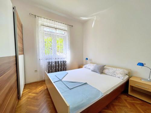 a bedroom with a large bed with a window at Apartments Bohovic in Šilo