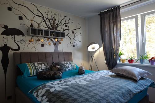 een slaapkamer met een blauw bed en een raam bij Apartman MIMA in Karlovac