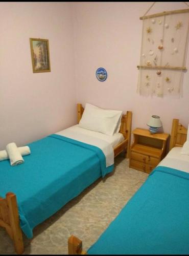 1 dormitorio con 2 camas individuales y mesa en AGNANTI en Palekastron