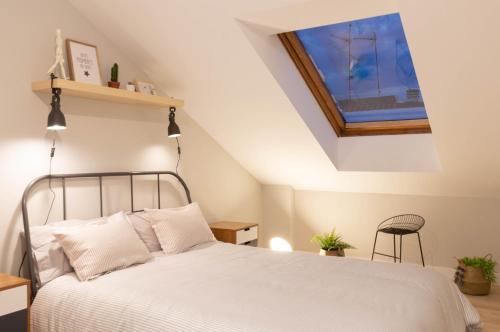 1 dormitorio con 1 cama blanca en el ático en La Plaza-Atico, en Villafranca de los Barros