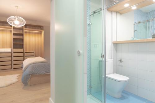 a bathroom with a shower and a toilet and a bed at La Plaza-Atico in Villafranca de los Barros