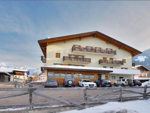 a large building with cars parked in front of it at Apartment Florian Pia by Interhome in Pozza di Fassa