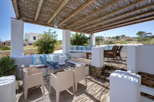 a patio with a table and chairs under a pergola at Koufonisi Villas in Koufonisia