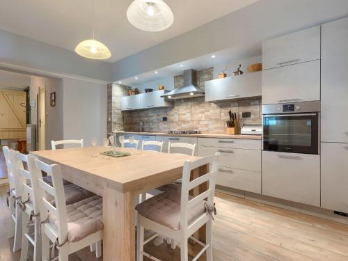 a kitchen with a wooden table and white cabinets at Holiday Home Villa Lancin - RCA453 by Interhome in Divšići