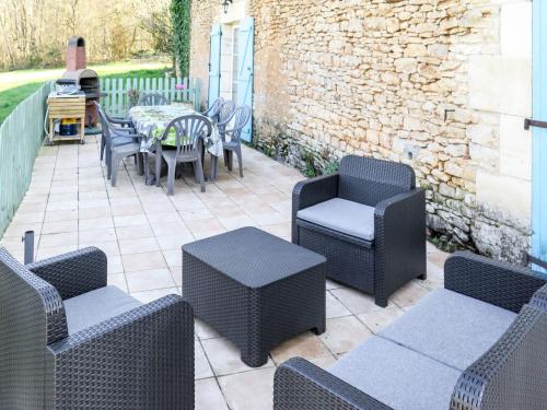 un patio con tavolo e sedie in vimini di Holiday Home Les Grèzes - MNB400 by Interhome a Montcabrier