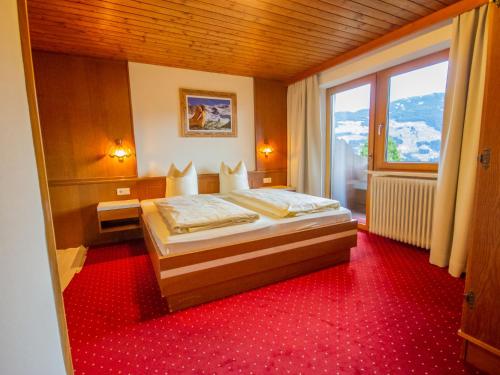 a bedroom with a bed and a large window at Apartment Brandegg Top 1 by Interhome in Fügenberg