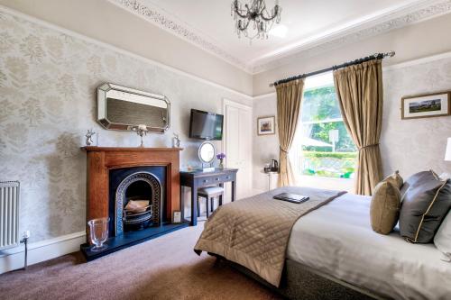 a bedroom with a bed with a fireplace and a mirror at The Hedges in Edinburgh