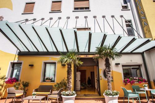 a hotel with palm trees in front of a building at Hotel Diana in Lido di Jesolo