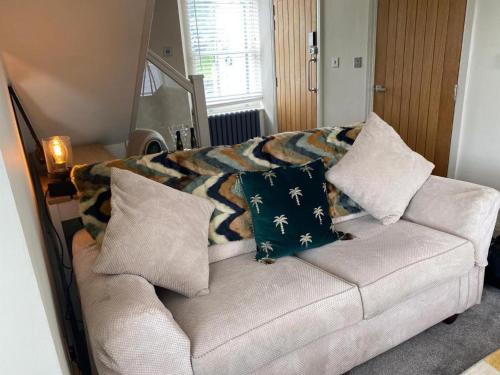 a couch with pillows on it in a living room at The Hive at Poppi-Red in Hawkshead