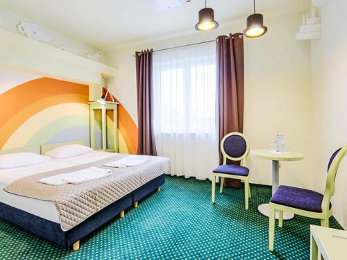 sypialnia z łóżkiem, 2 krzesłami i stołem w obiekcie Hotel Magiczny Zakątek w mieście Raszowa