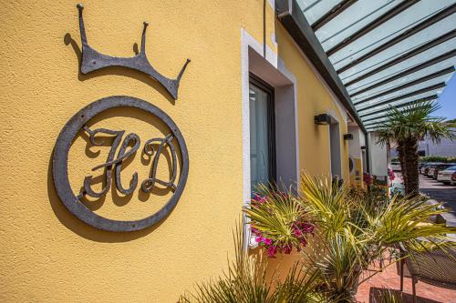 a sign on the side of a building with plants at Hotel Diana in Lido di Jesolo