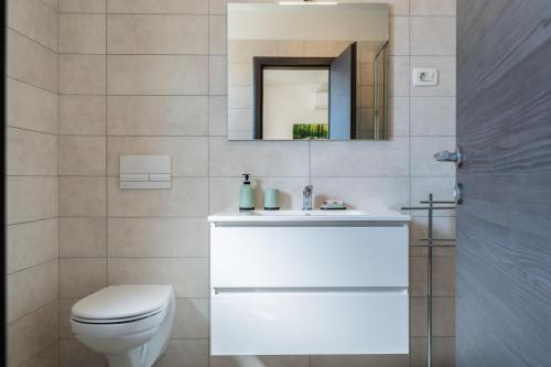 a bathroom with a white toilet and a mirror at Villa Vanda in Diminići
