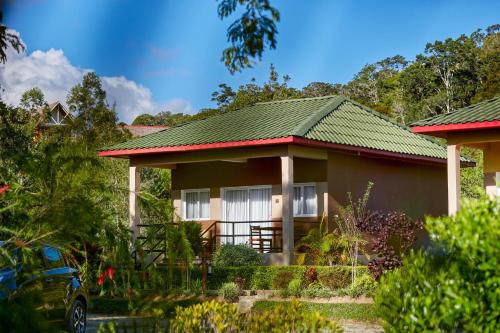 a house with a green roof at Andasibe Lemurs Lodge in Andasibe