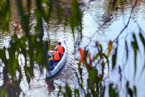 two people in a small boat on the water at Andasibe Lemurs Lodge in Andasibe