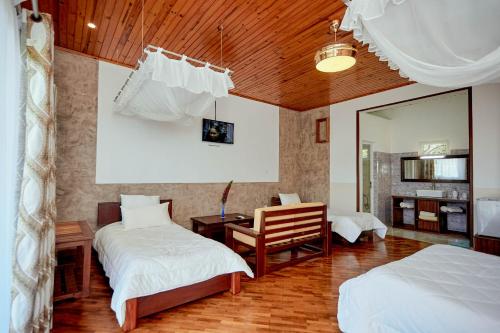a bedroom with two beds and a desk and a mirror at Andasibe Lemurs Lodge in Andasibe