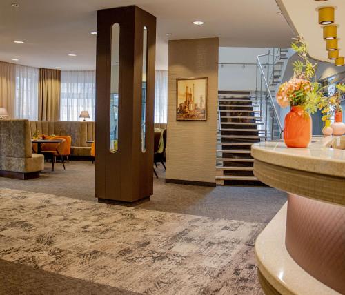 un vestíbulo con una escalera y una habitación con una mesa en Hotel Essener Hof; Sure Hotel Collection by Best Western en Essen
