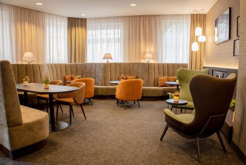 a waiting room with tables and chairs and a couch at Hotel Essener Hof; Sure Hotel Collection by Best Western in Essen